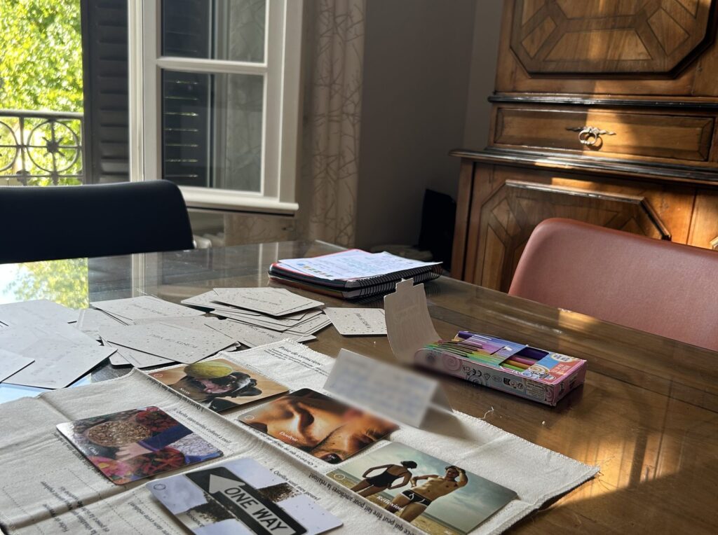 Cartes de photolangage étalées sur une table, devant une fenêtre ouverte